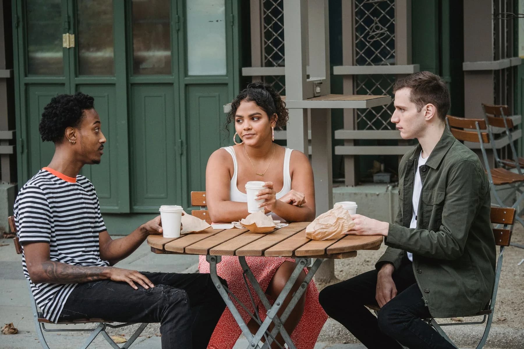 Friends sharing conversation over coffee at an outdoor cafe